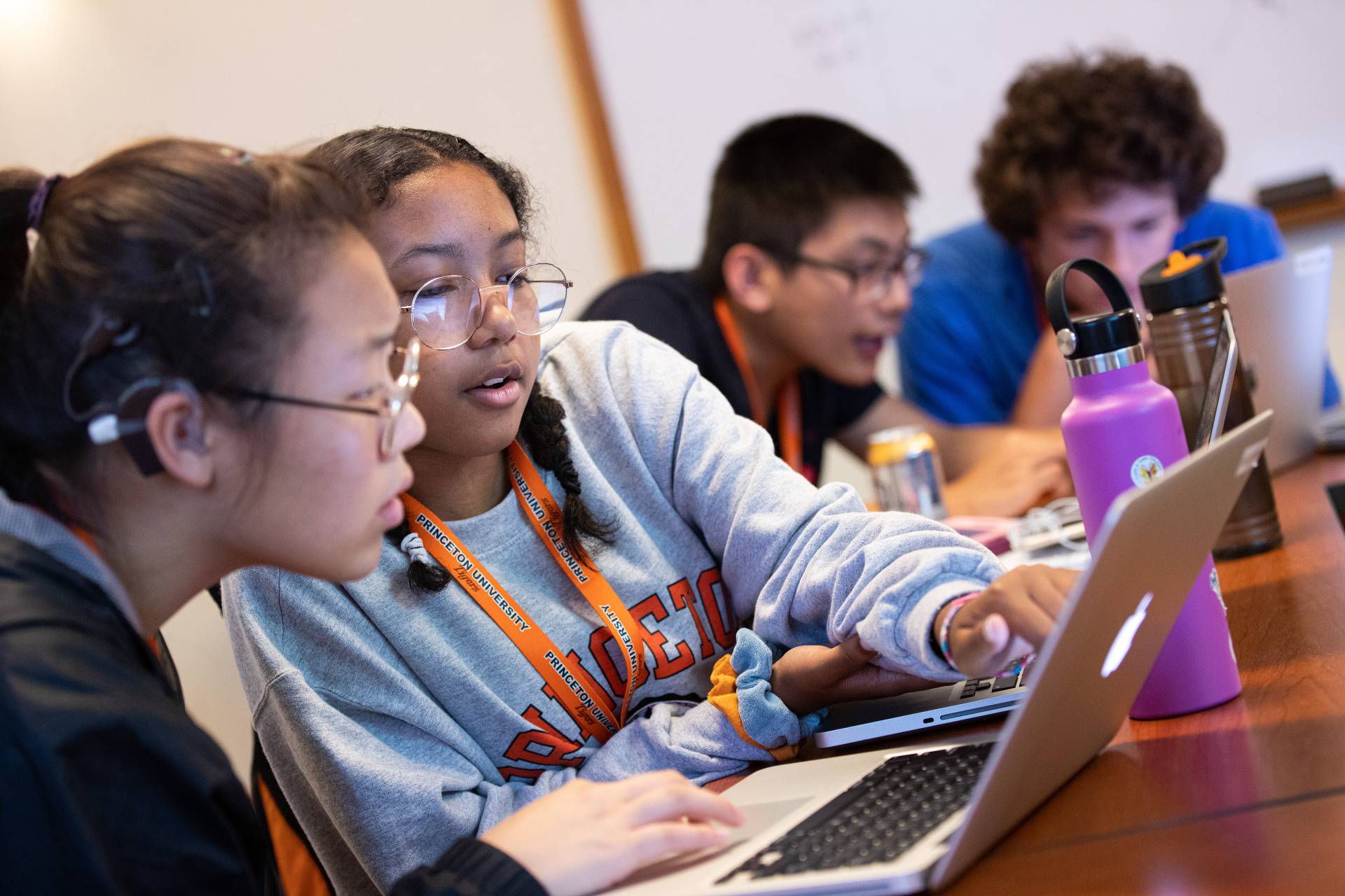 High school students working together in front of laptops.