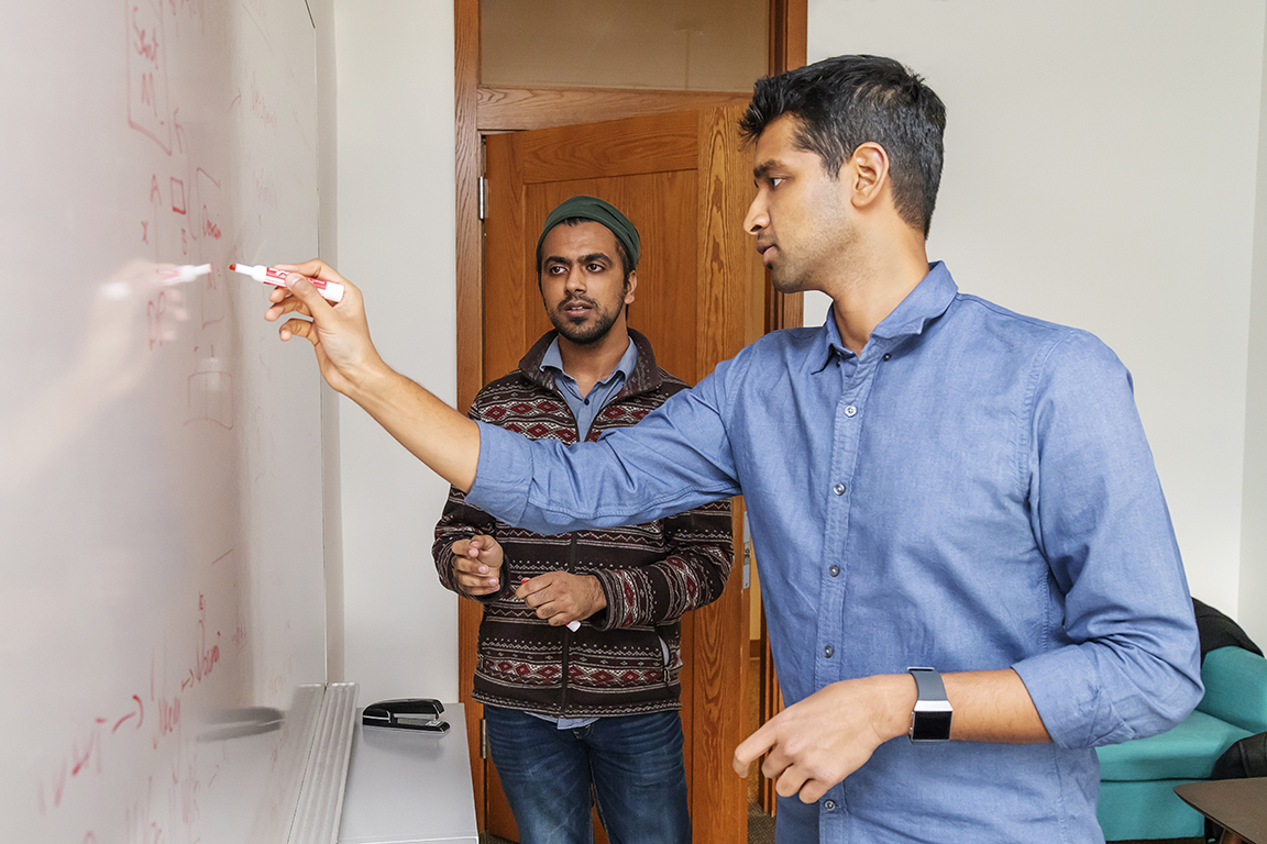 Karthik Narasimhan standing at a white board with undergraduate student Karan Arora, C.S. class of 2019