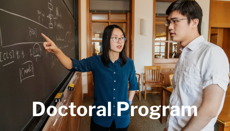 faculty pointing at blackboard talking to a student